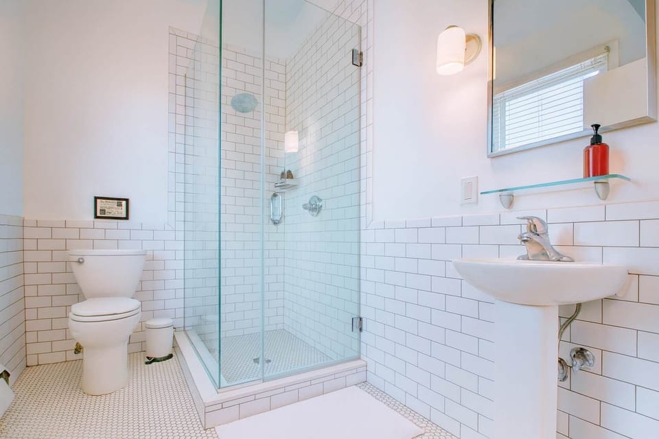 Bright, modern bathroom with subway tile, glass shower, and clean lines—spotless, fresh, and designed for comfort.
