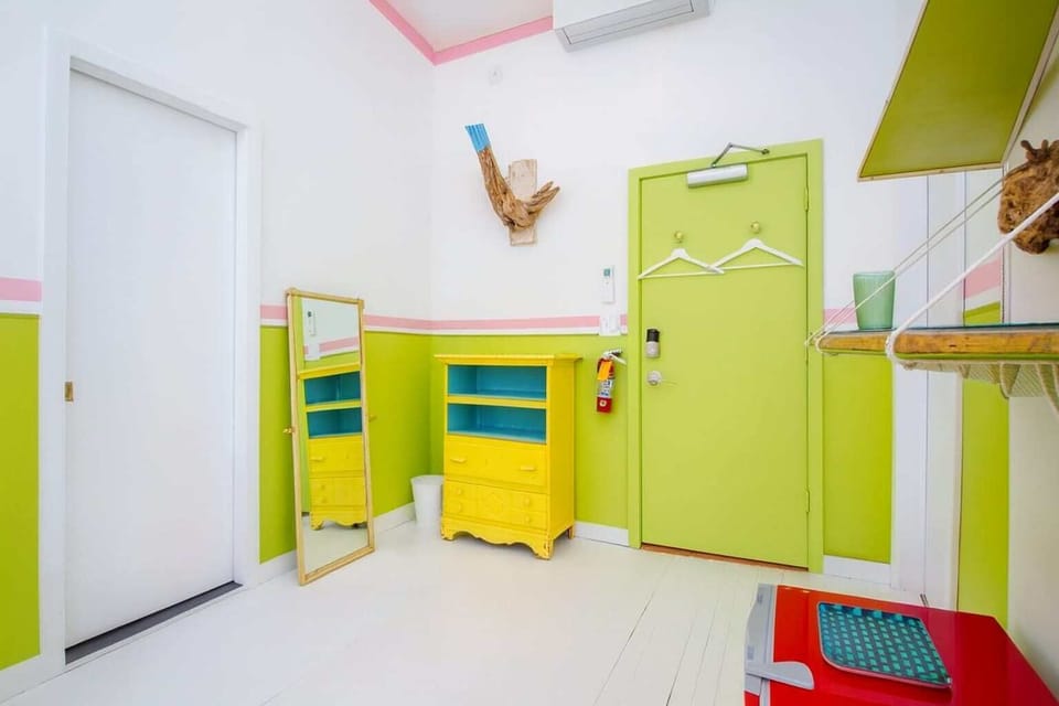Vibrant, well-organized room with smart storage, bold green accents, and playful design—clean, bright, and full of character.
