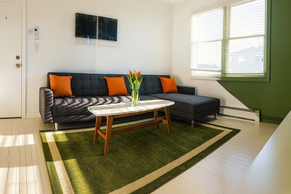 Bright, modern living area with cozy sectional, bold accents, and natural light—stylish, comfortable, and perfect for relaxing.
