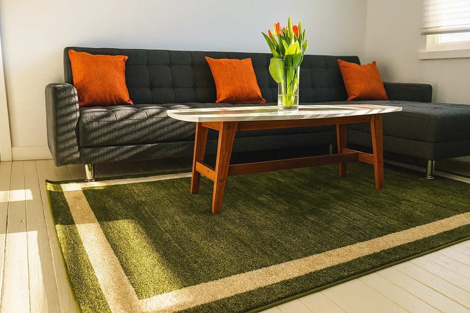 Stylish living room with cozy sectional, warm accents, and natural light—comfortable, modern space perfect for relaxing or gathering.
