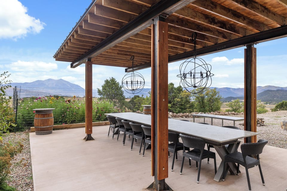 outdoor dining table has new pergola and lighting for dinner gatherings 