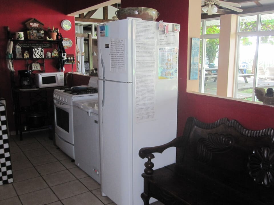 Kitchen with fridge, stove, freezer & seating bench. Great view of beach.