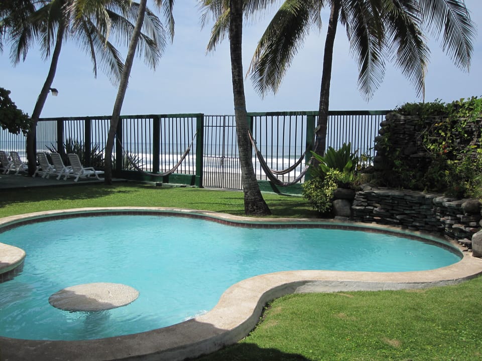 Pool view looking out to ocean. Pool seating & table for entertaining.