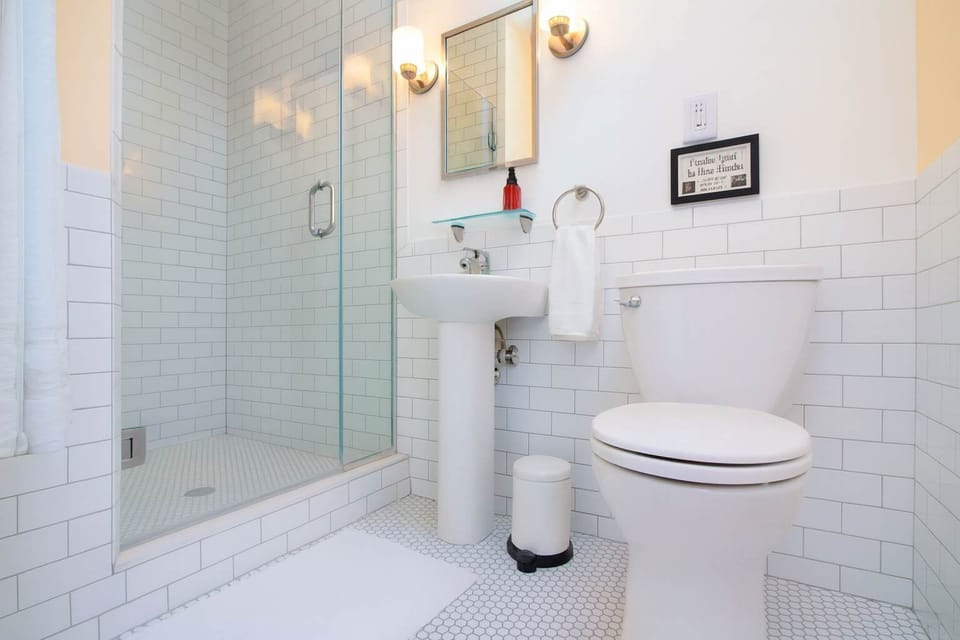 Bright, spotless bathroom with subway tile, glass shower, and modern fixtures—fresh, stylish, and designed for everyday comfort.
