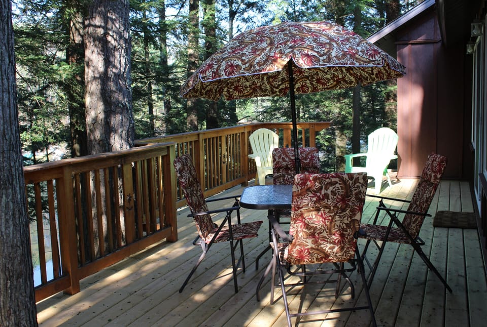 A large deck is on the lakeside of the cottage reached by sliding glass door.