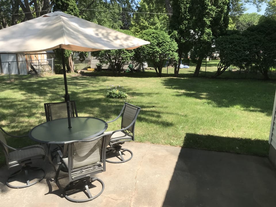 Spacious backyard with patio furniture and gas grill great for tailgating.