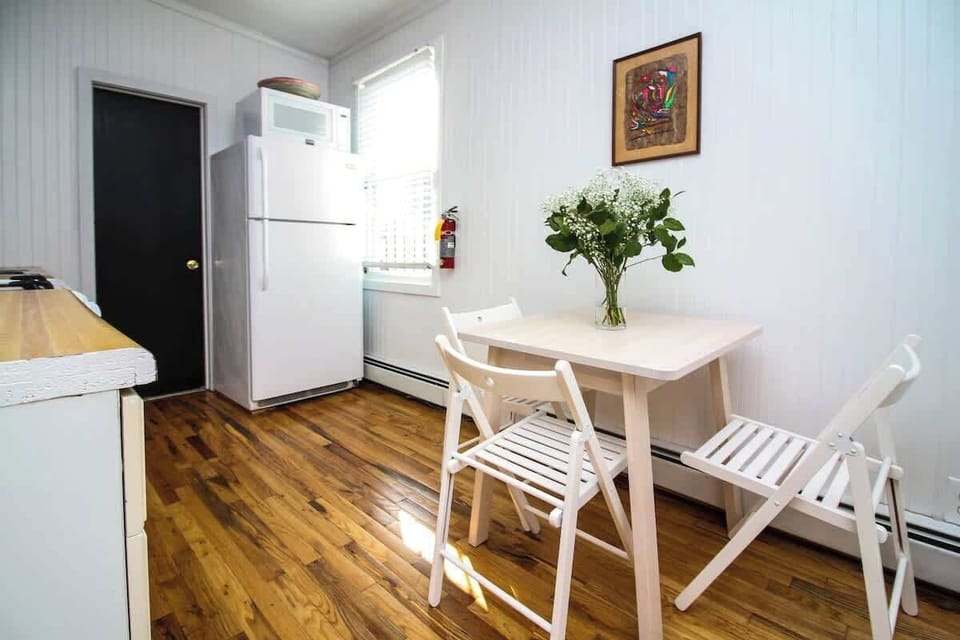 Bright dining nook with cozy table seating, warm wood floors, and natural light—perfect for meals, coffee, or planning your day.
