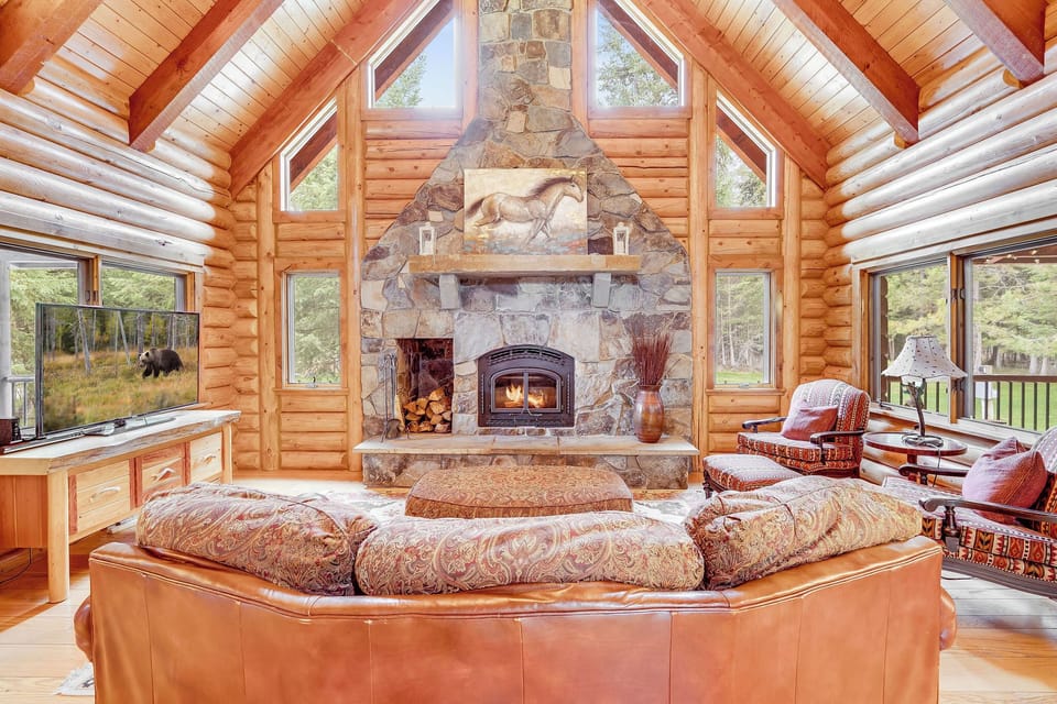 Main living room with floor to ceiling fireplace, flat screen TV