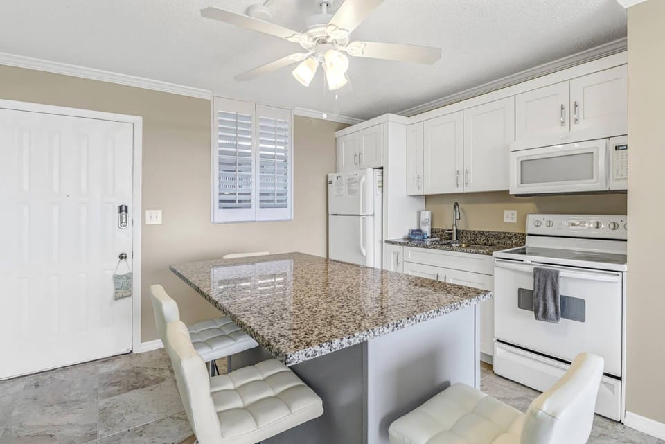 The newly remodeled kitchen enjoys a spacious center island with high top seating for 4.