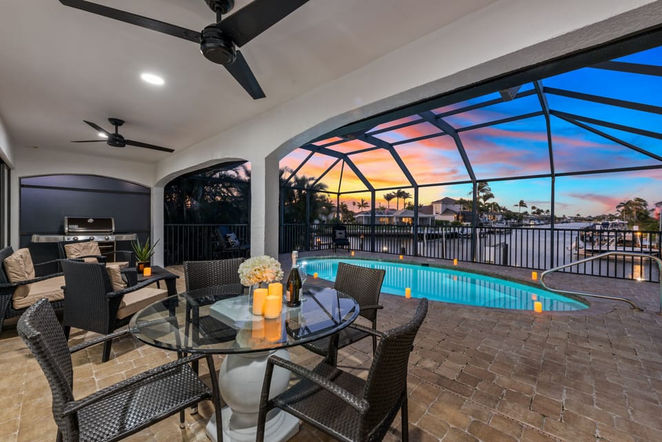 Covered lanai with relax water views, dining, chaise lounges and weber grill