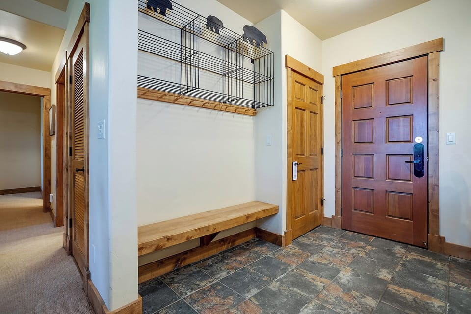 Your welcoming entryway features rustic wood benches and storage cubbies, perfect for organizing gear after mountain adventures.