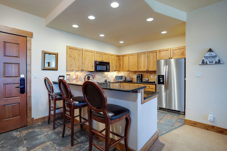 Your spacious kitchen features granite counters, stainless appliances, and a breakfast bar perfect for morning coffee or evening wine.