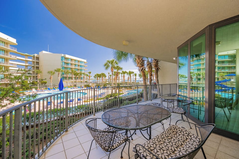 Breathe in the fresh air from the balcony while enjoying glimpses of the inviting pool and lush palm trees