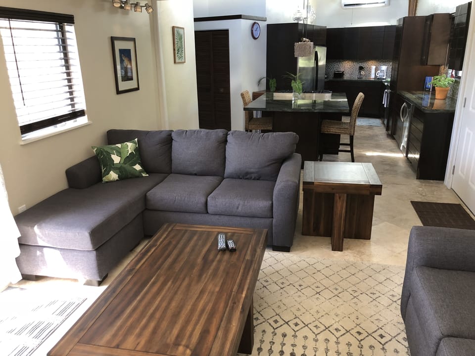 Living room looking into huge kitchen.  Sliding glass door on left entering pool