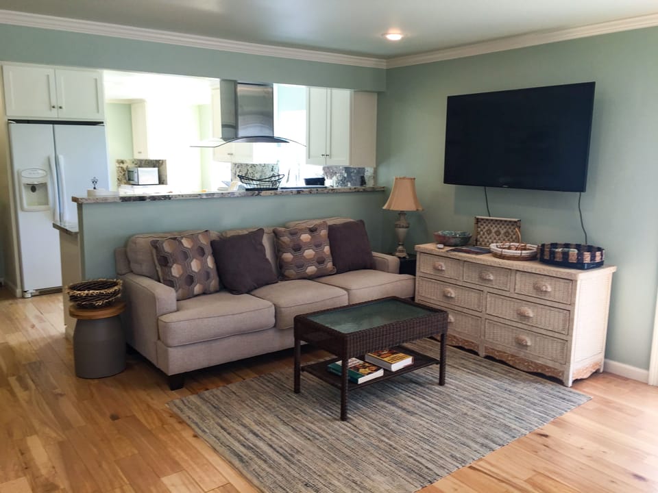 Large living area opens onto private patio with glimpses of bay.