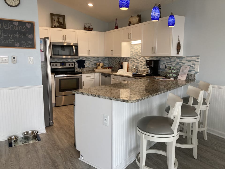 WELL-EQUIPPED KITCHEN WITH A BAR/BREAKFAST NOOK.