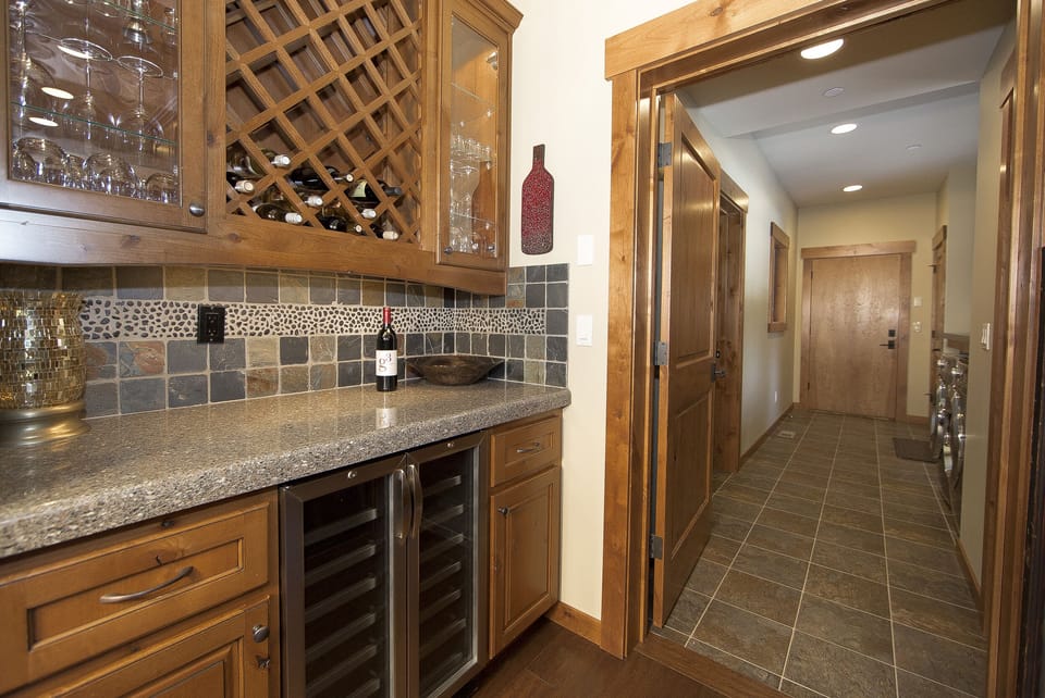 Cheers! Wine butler stocked w/stemless/stemmed wine glasses. Wine fridge below.