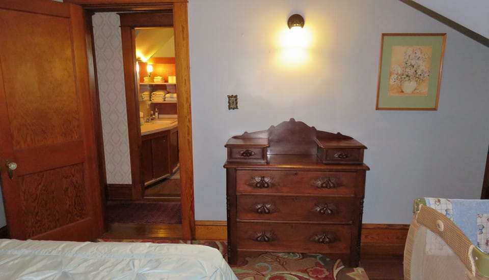 Upstairs bedroom with queen bed crib directly across from the bathroom