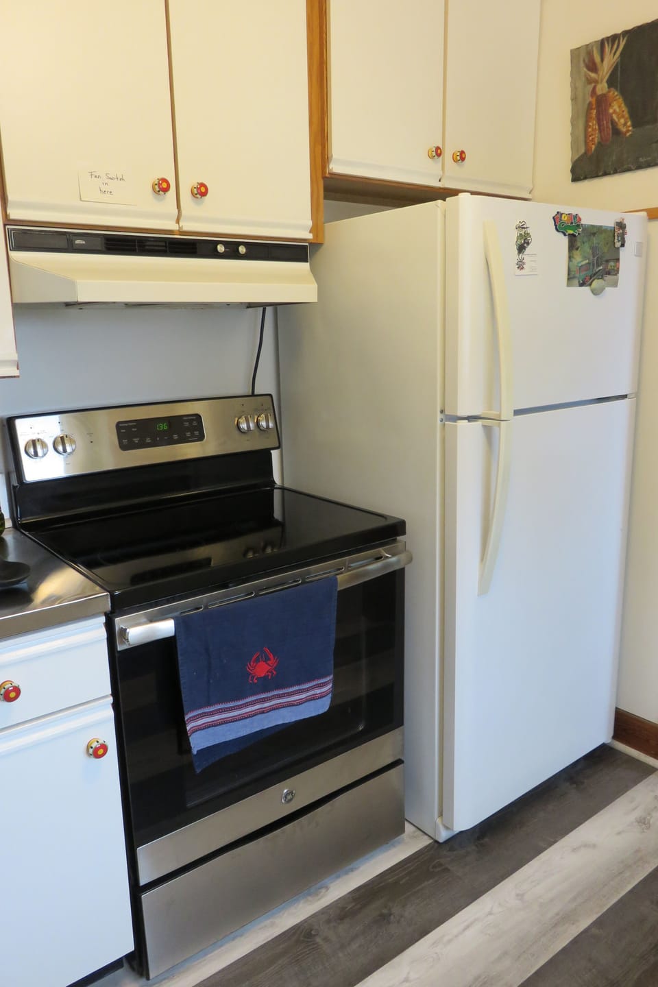 Kitchen with 30" glass top self-cleaning range and refrigerator
