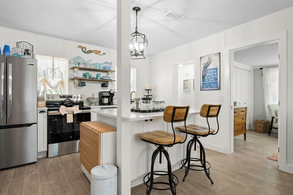 Open kitchen with eat-at-island and drop-leaf table for additional dining.