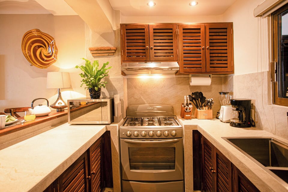 REMODELED KITCHEN WITH NEW COUNTERS, BAR, SINK AND LIGHTING 
