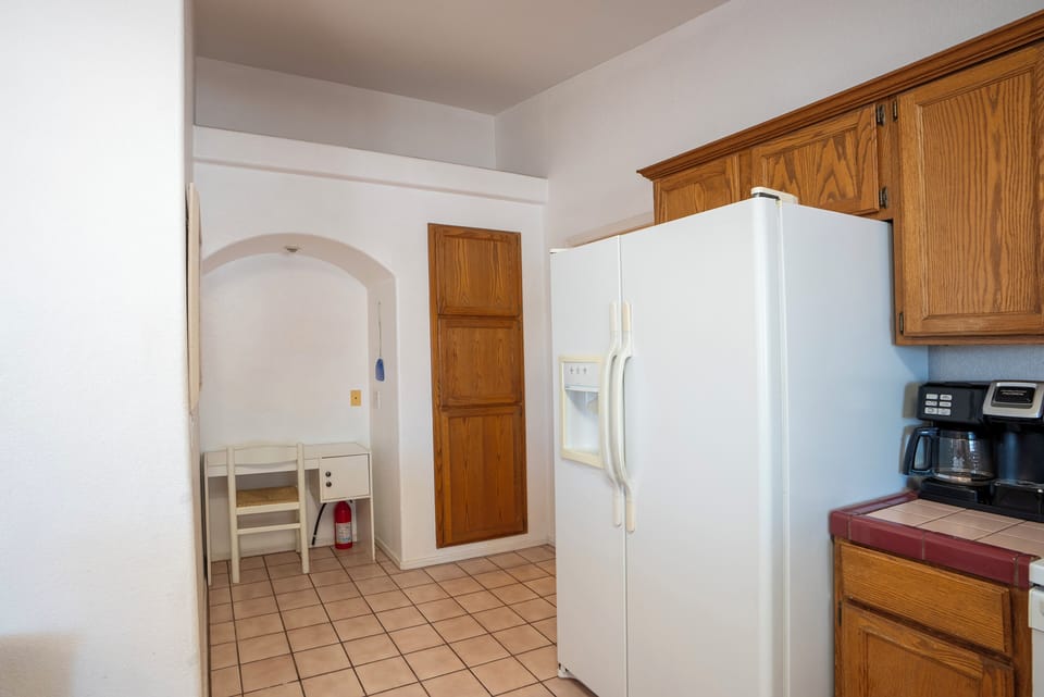 Large side by side fridge,  desk area and utility closet. 
