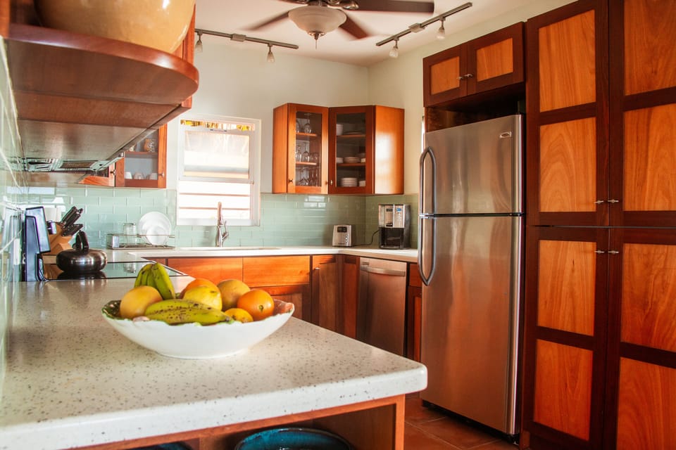 Washer and dryer to right of refrigerator behind cabinet doors.