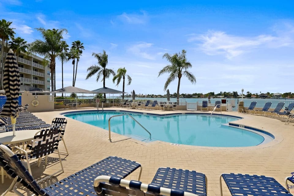 Soak up the sunshine at this beautiful community pool featuring crystal-clear water, plenty of lounge chairs, tropical palm trees, and stunning bay views. Enjoy a peaceful afternoon relaxing poolside.