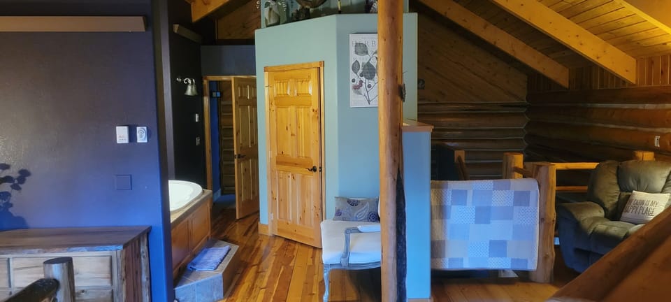Master bedroom view to closet and jet tub. half wall is seen near the log 