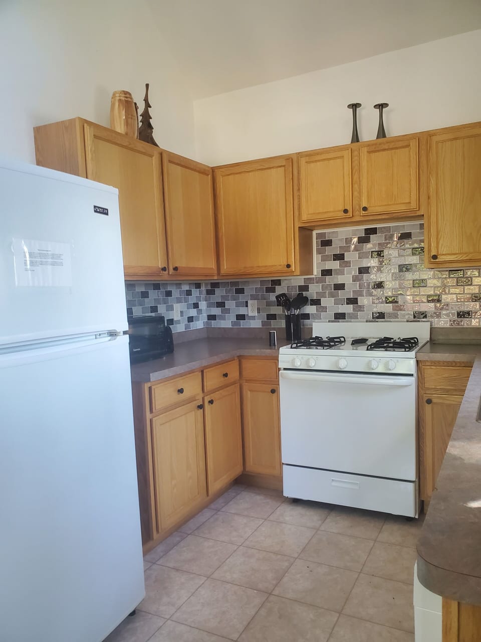 Kitchen features gas stove, refrigerator, dishwasher for all your cooking needs