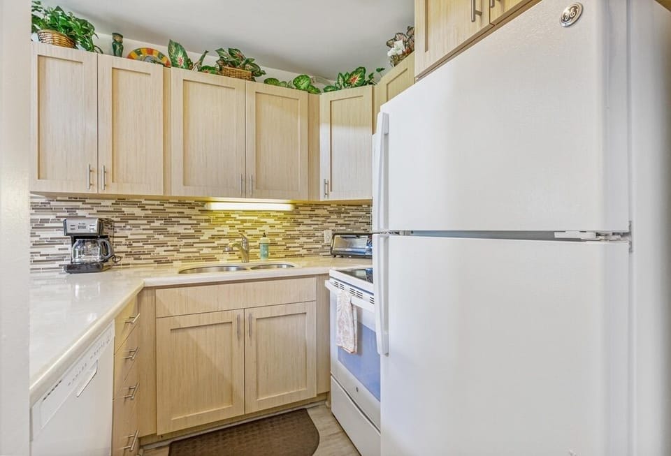 Whip up your favorite meals in this bright, well-equipped kitchen featuring modern appliances and beautiful mosaic backsplash details.