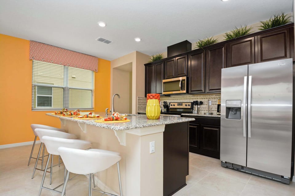 Open-concept kitchen with island seating and modern stainless setup-ideal for entertaining as guests mingle.