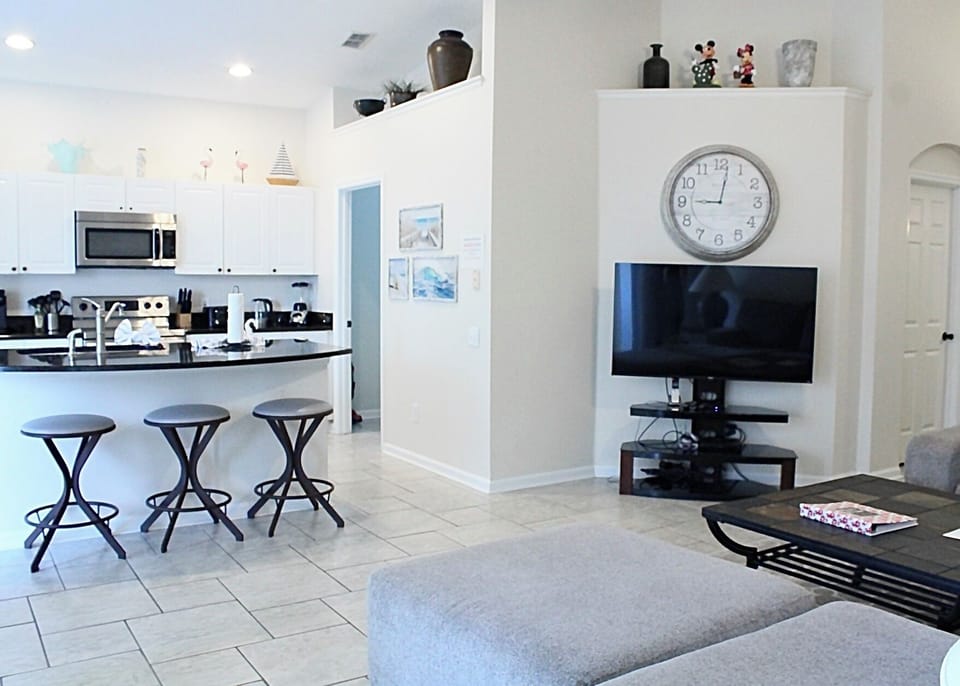 Spacious family room couch with flatscreen tv and large kitchen with Keurig.