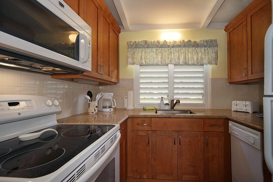 Full kitchen - well appointed and includes wood cabinets and granite counter top