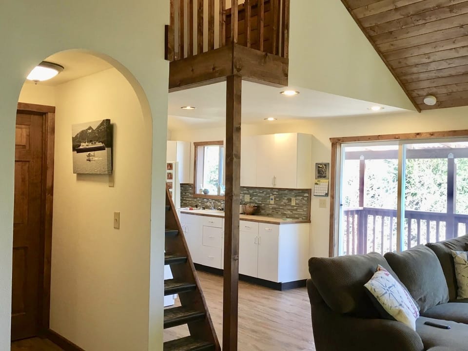 View from entry looking at living/kitchen and going up to loft that has a queen 