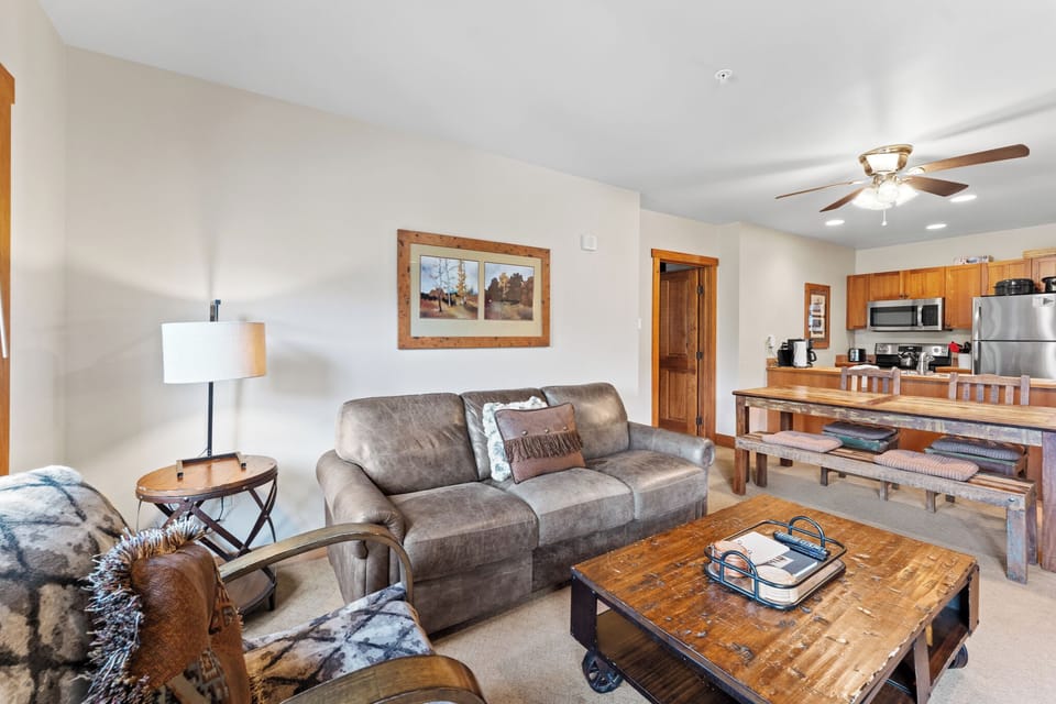 Relax in your cozy living space with plush seating, rustic wood touches, and an open kitchen perfect for preparing meals together.
