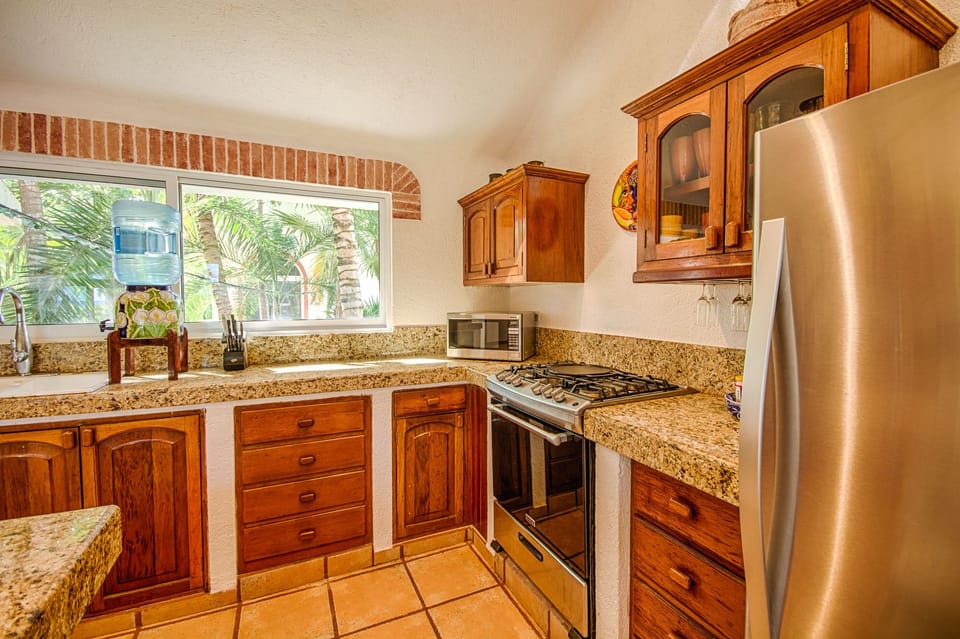 The kitchen is fully equipped with stainless steel appliances, granite counters.