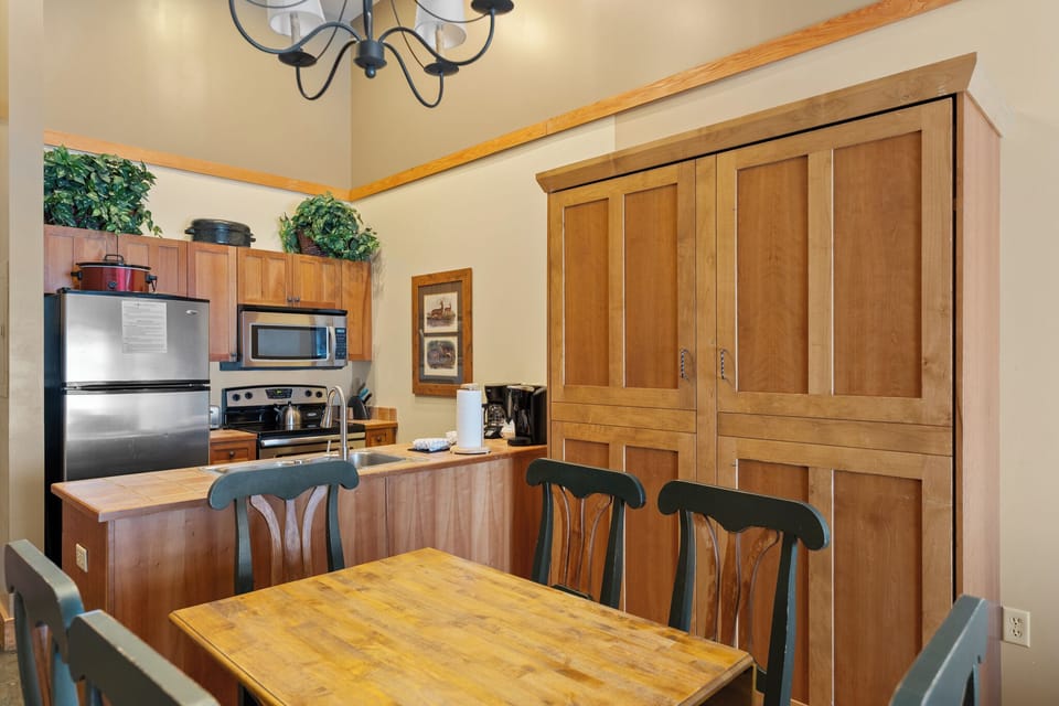 Gather around the warm wooden dining table while you prepare meals in your fully-equipped kitchen with stainless steel appliances.