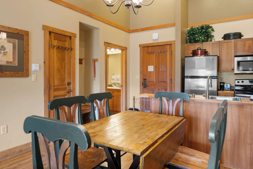 Gather around your dining table where warm wood tones and cozy lighting create the perfect setting for memorable meals together.