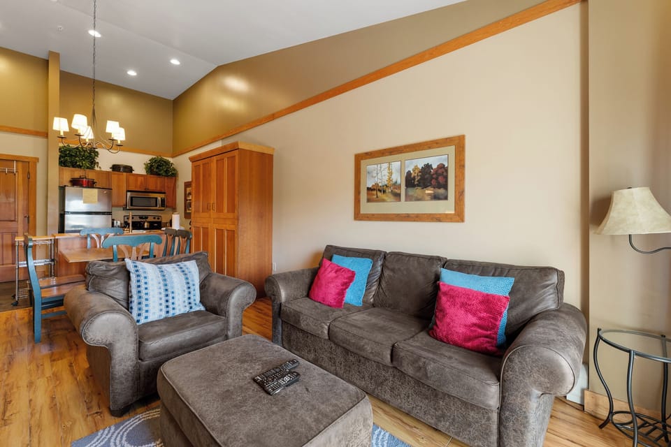 Cozy up in your stylish living room with plush seating and vibrant pillows, where warm wood touches create the perfect retreat.