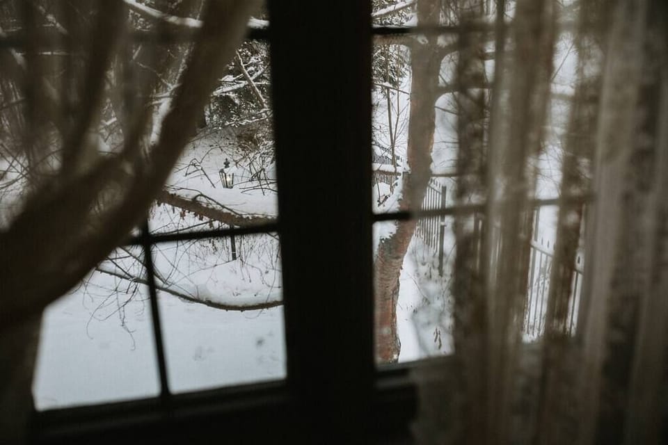 Snowy views framed by delicate lace curtains, bringing the beauty of winter indoors