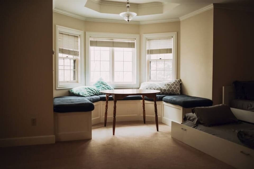 Bright and cozy bay window nook, perfect for enjoying a peaceful moment or reading with natural light.