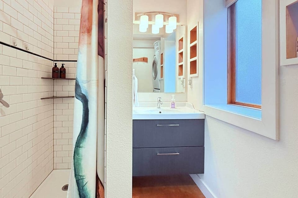 Half bath with shower and full vanity. Shampoo, conditioner and locally made soap provided. The stacked laundry set is also in this room.
