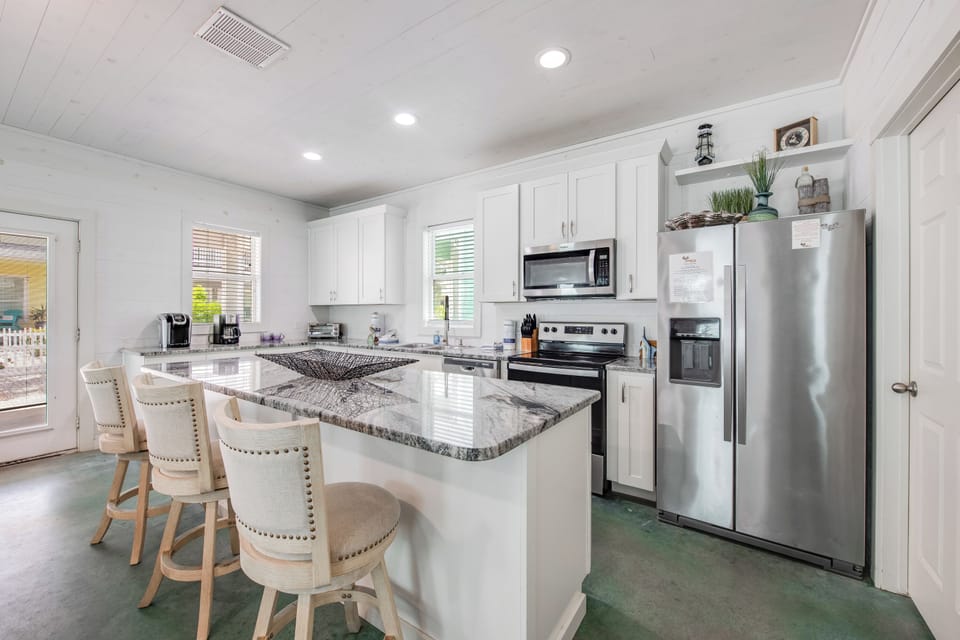 Gather around your bright, fully-equipped kitchen featuring stunning granite counters, stainless steel appliances, and a breakfast bar perfect for morning coffee.
