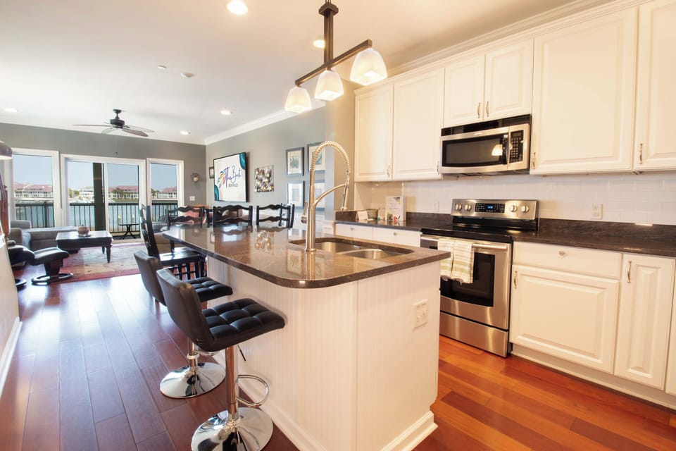 Cook memorable meals in your spacious kitchen with granite counters, stainless appliances, and waterfront views beyond.