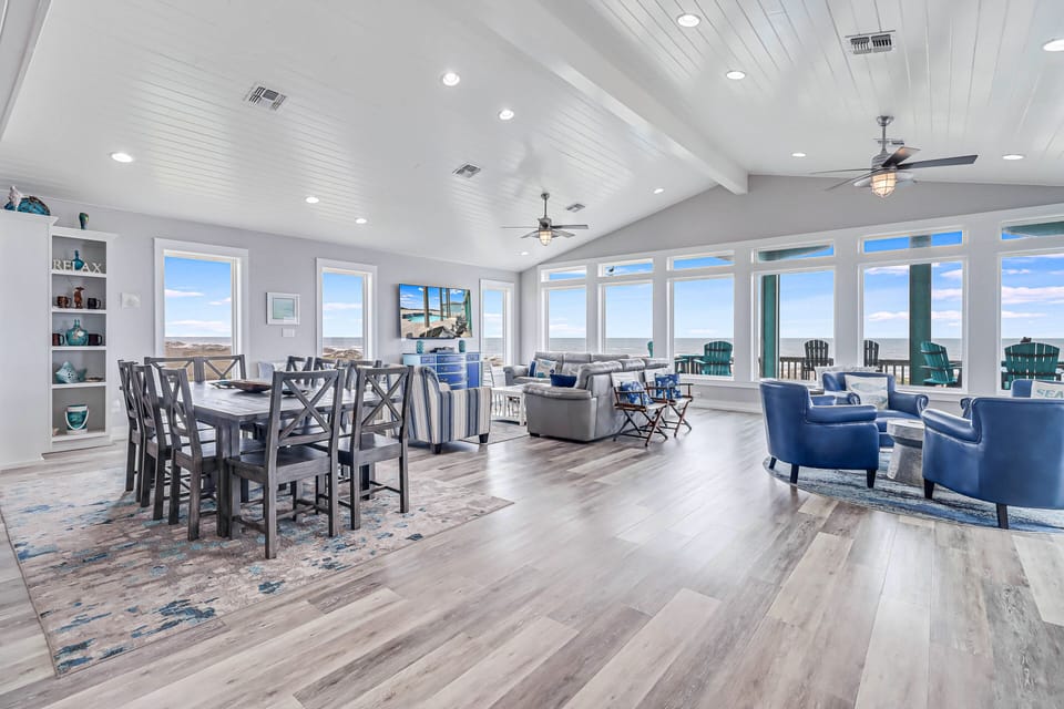 Relax in your spacious coastal retreat with panoramic windows, comfortable seating, and elegant dining space perfect for memorable meals.