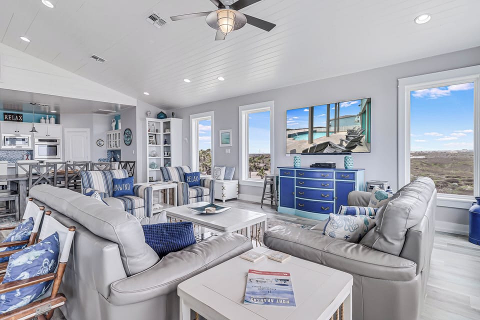 Unwind in your coastal living room where ocean views meet comfortable seating and nautical charm creates the perfect retreat.