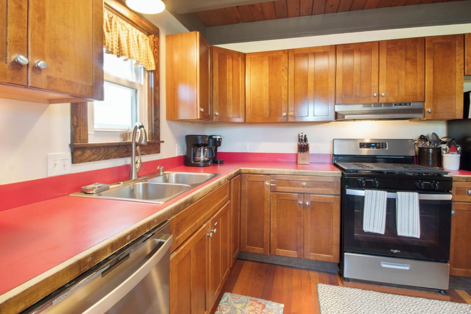 Your fully equipped kitchen awaits with warm wood cabinetry, vibrant countertops, stainless appliances, and everything you need to prepare delicious home-cooked meals during your stay.