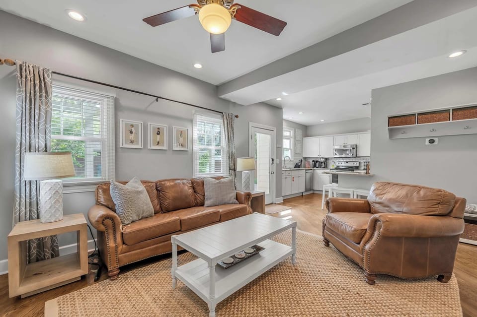 Enjoy Southern charm with modern flair in this open-concept living room, complete with stylish décor, comfortable seating, and a Smart TV for effortless relaxation and entertainment.