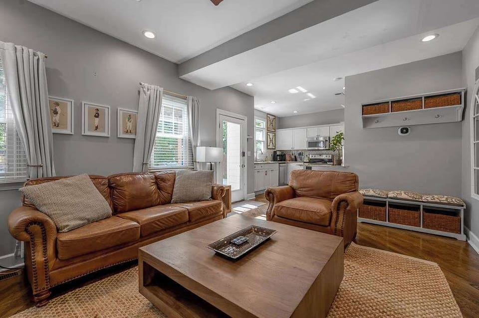 Open living room with a leather sofa, window bench and coffee table for game night.